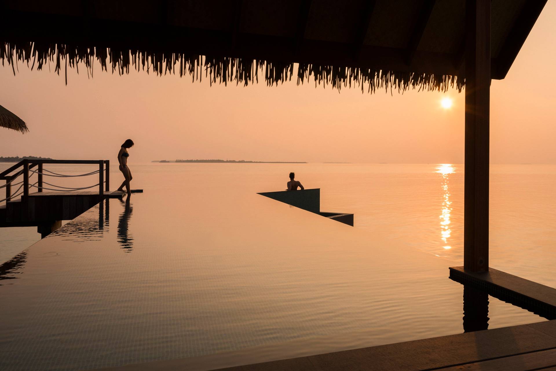 Coppia piscina resort Maldive al tramonto